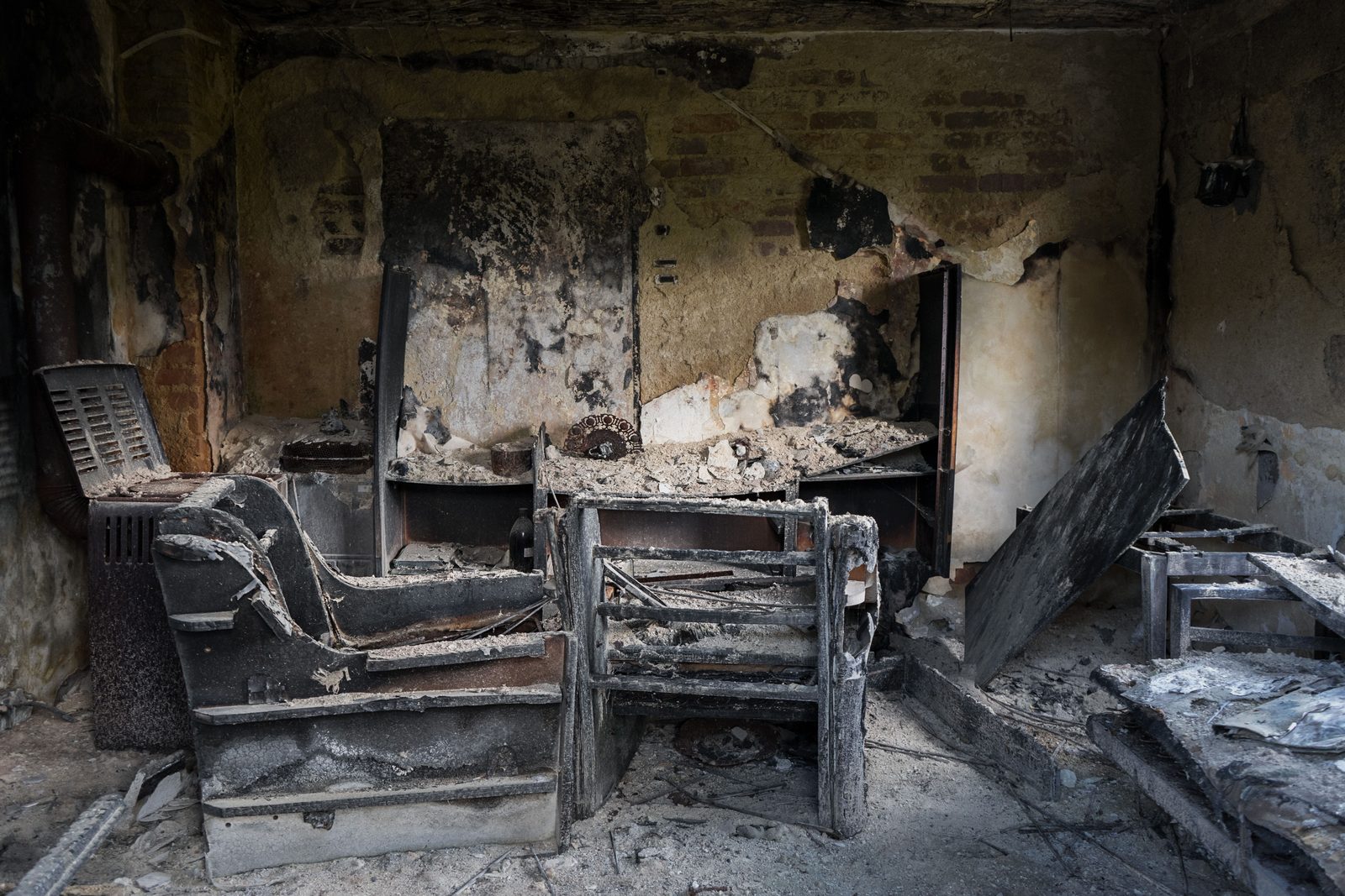 Living room with heavy soot and fire damage on the walls and furniture